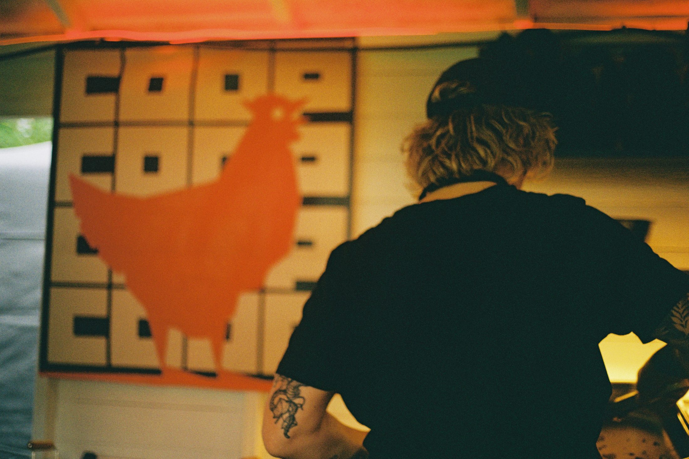 Staff at COOP in front of the painted chicken mural