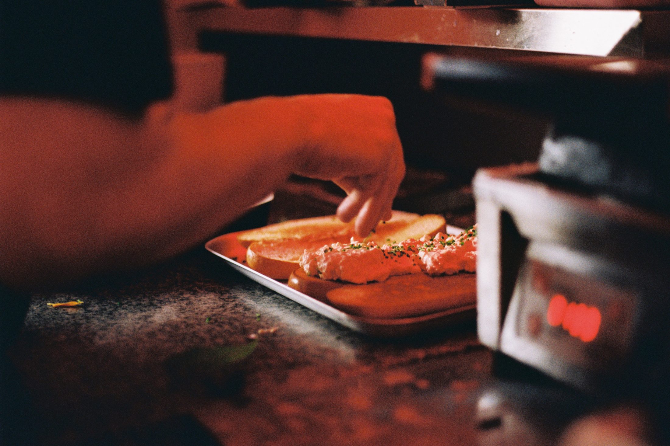 Hands plating fried chicken in the COOP kitchen